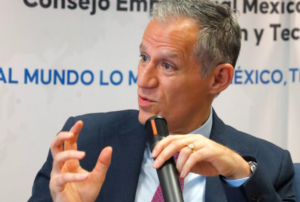 Kenneth Smith fala diante dos microfones em uma coletiva de imprensa sobre a posição dos Estados Unidos na revisão do T-MEC e o papel de Jamieson Greer nas negociações.