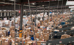 Logistics center with boxes, conveyors, and operational staff in an automated warehouse. The infrastructure reflects Walmart’s artificial intelligence processes, inventory management, and supply chain optimization.