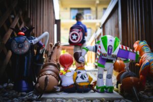 Toys from an animated film watch as a child with a backpack walks away down a residential hallway, suggesting the economic impact on children when tariffs drive up the cost of imported toys. Tariffs on toy imports affect employment: The Toy Association.