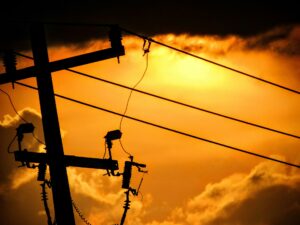 Poste eléctrico con cables dañados y deterioro visible, imagen que representa el riesgo de fallas energéticas para la productividad industrial.