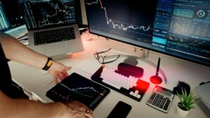 Vista superior de un espacio de trabajo digital con múltiples pantallas mostrando gráficos financieros y datos empresariales en tiempo real, ilustrando la infraestructura tecnológica necesaria para la gestión moderna. Comparativa de software contable y administrativo en México 2026.