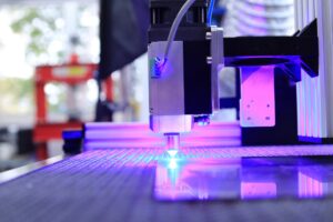 Industrial laser cutting machine operating in a modern factory, illustrating how laser technology improves precision, efficiency, and sustainability in manufacturing.