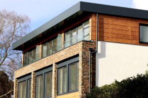 Edificio residencial de tres pisos con diseño arquitectónico moderno. La fachada presenta una combinación de paneles de madera cálida, mampostería de piedra texturizada y estuco blanco limpio, con múltiples ventanas grandes. Casas en renta en San Luis Potosí: opciones y precios.